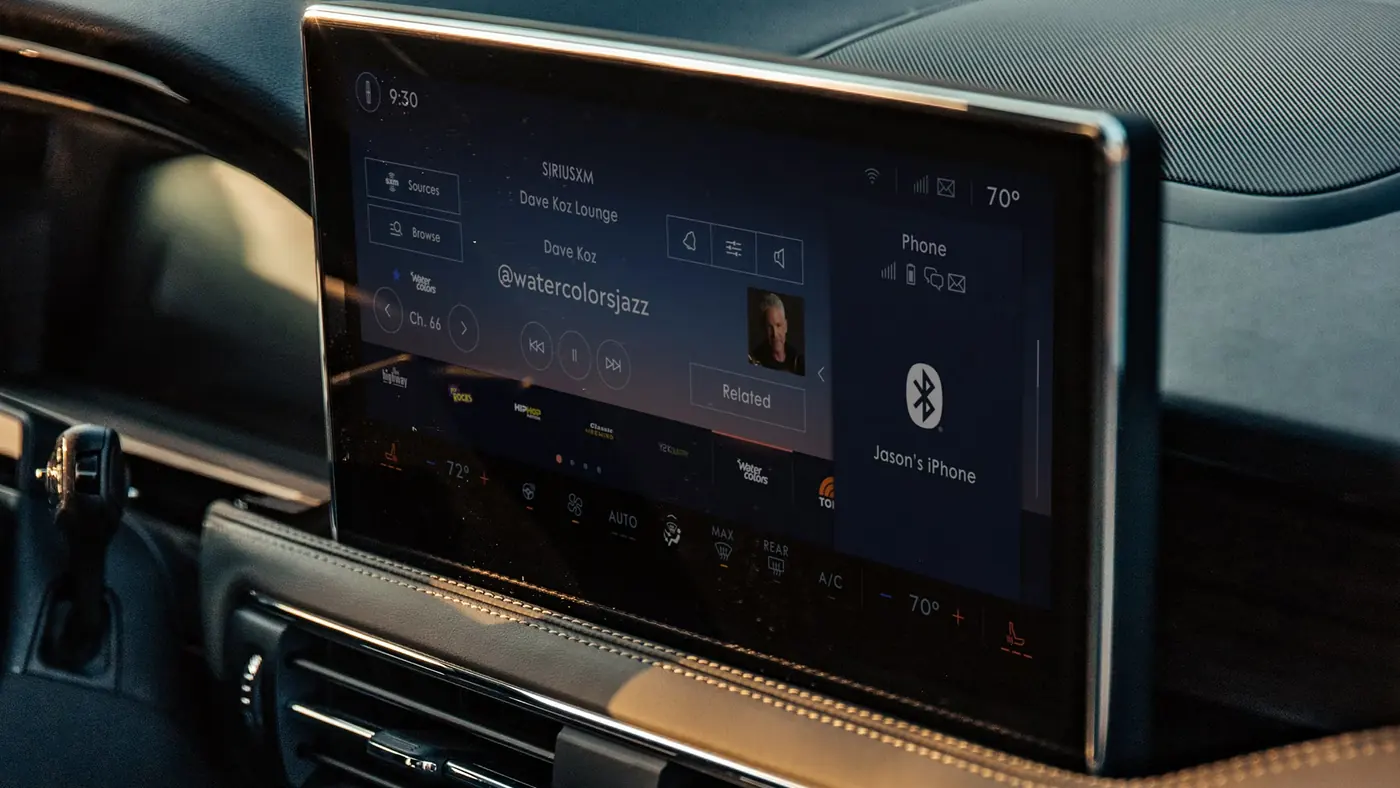 A vehicle cabin display running media, climate and phone controls