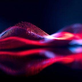 A red dotted wave of light on a dark surface