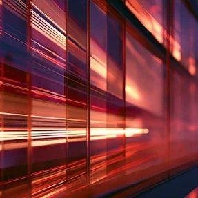 Red and violet light streaking across glass panels