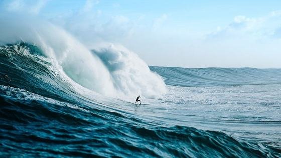 A surfer riding a large breaking wave