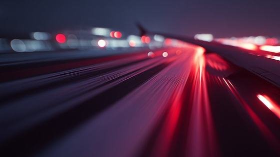 Red light trails along an aircraft wing at night