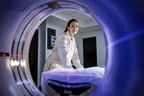 A clinician at a CT scanner in a diagnostic imaging suite